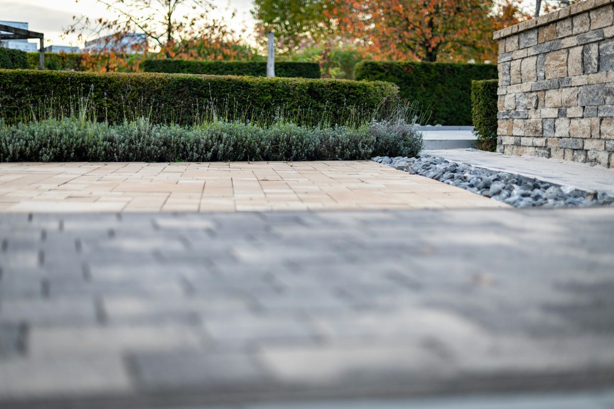 Landscaper planting out a garden bed behind a stone retaining wall