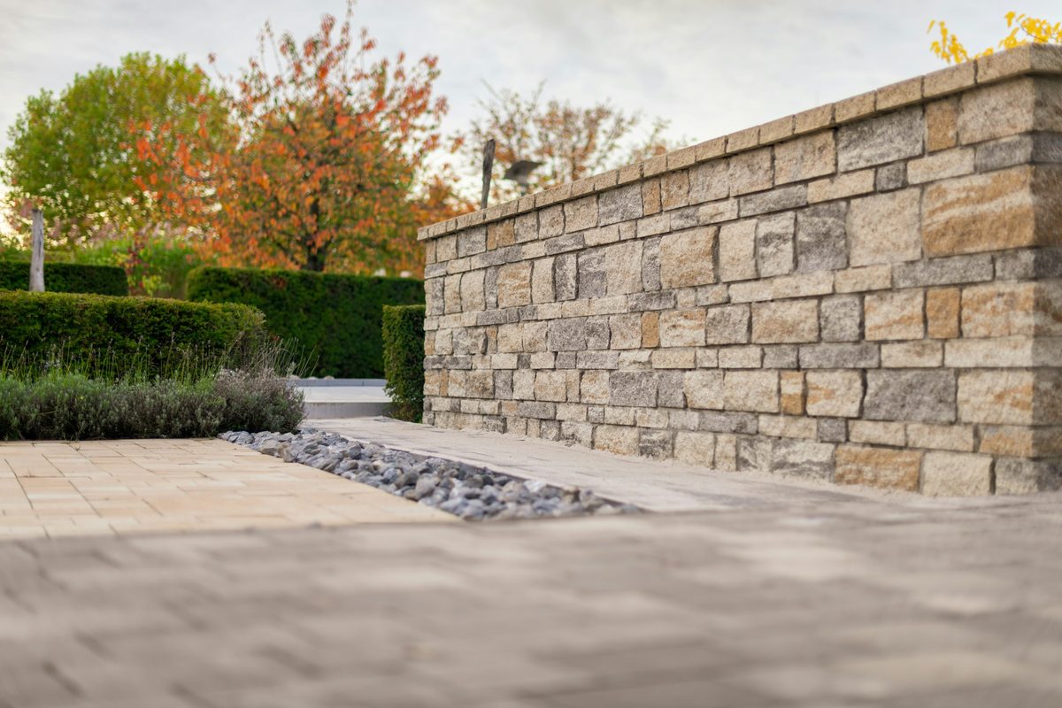 Tradesman laying concrete blocks on a new retaining wall
