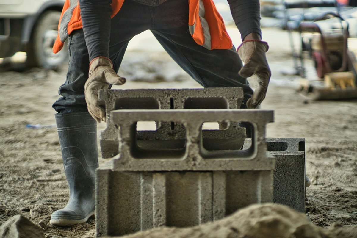Spirit level being checked across a course of retaining wall blocks